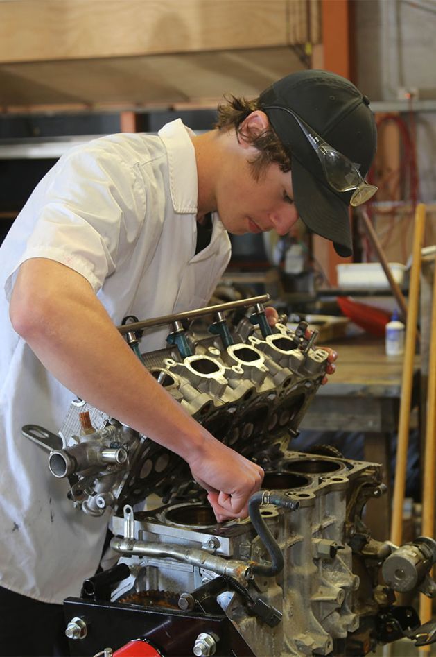 Senior years mechanic student working on car engine